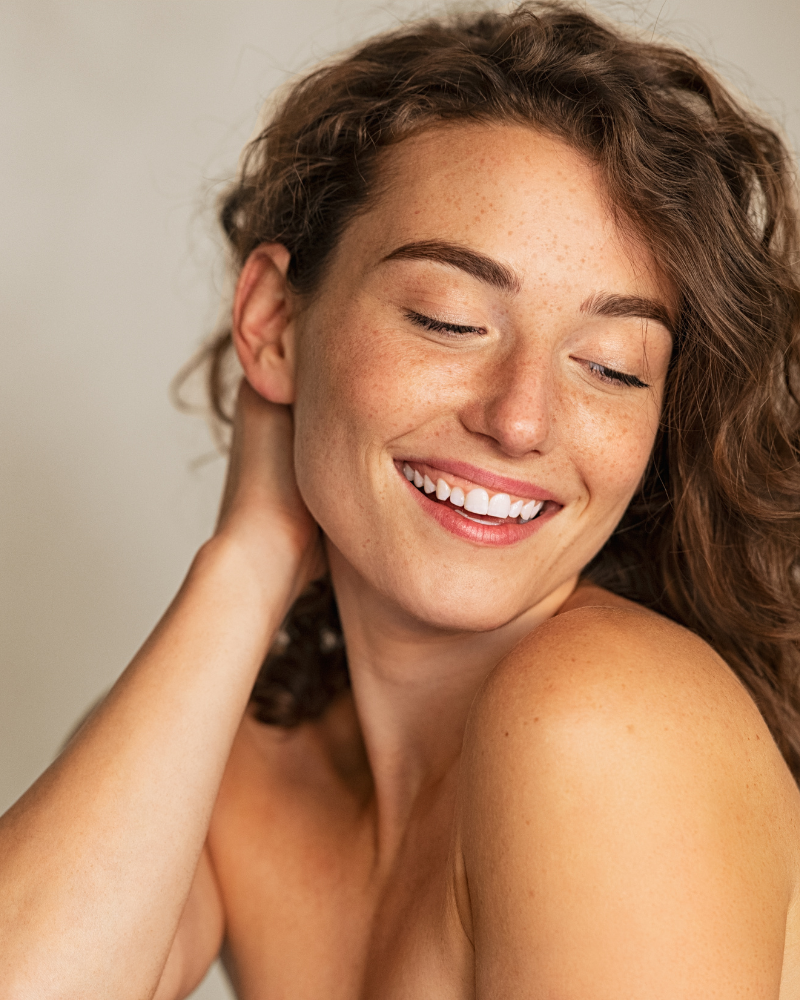 Woman with freckles holding her head